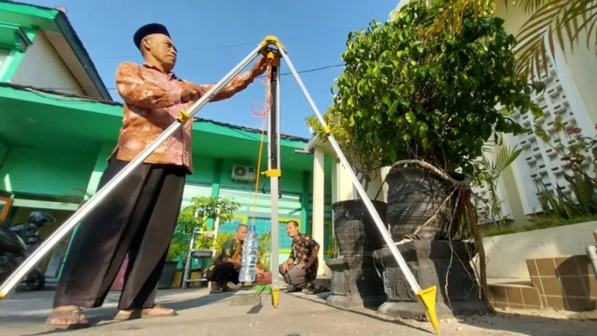 Tim Seksi Bimas Islam Kemenag Tuban menandai bayang matahari sebagai arah kiblat di halaman kantornya kemarin (15/7) pukul 16.27. (M. MAHFUDZ MUNTAHA/RADAR TUBAN)