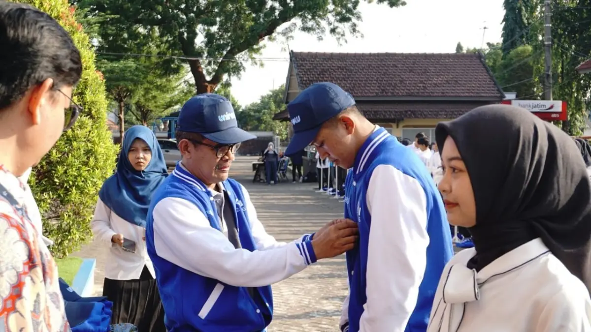 Rektor Unirow Prof Dr Warli M Pd didampingi Kakanwil BPJS Ketenagakerjaan Jatim Irvansyah Utoh Banja menyematkan atribut KKN kepada perwakilan mahasiswa Unirow di kampusnya, kemarin (20/7). (UNIROW UNTUK RADAR TUBAN)