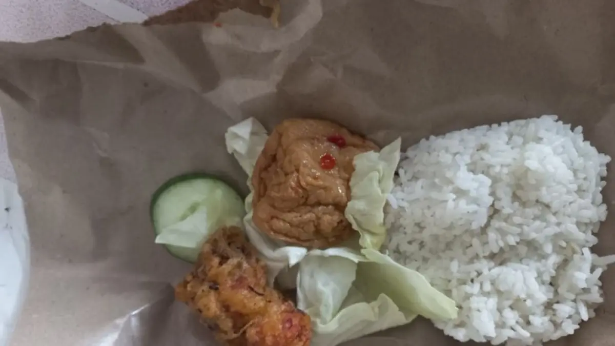 Menu MBG untuk balita yang hanya berupa nasi, tahu goreng, kubis, potongan mentimun, dan lauk yang dimbel-mbel tepung.&nbsp;(Ahmad Atho