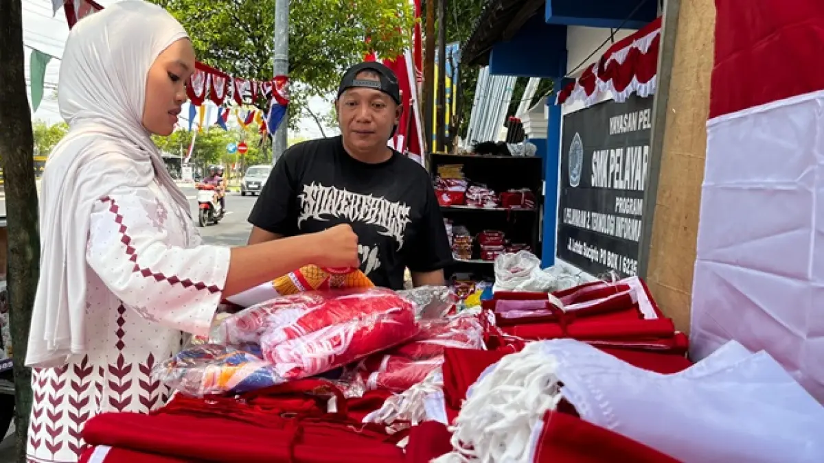 Salah satu pembeli pernak pernik kemerdekaan di Jalan Letda Sucipto tengah memilih bendera Merah Putih menjelang HUT Kemerdekaan RI. (Shafa Dina Hayuning Mentari/Radar Tuban)