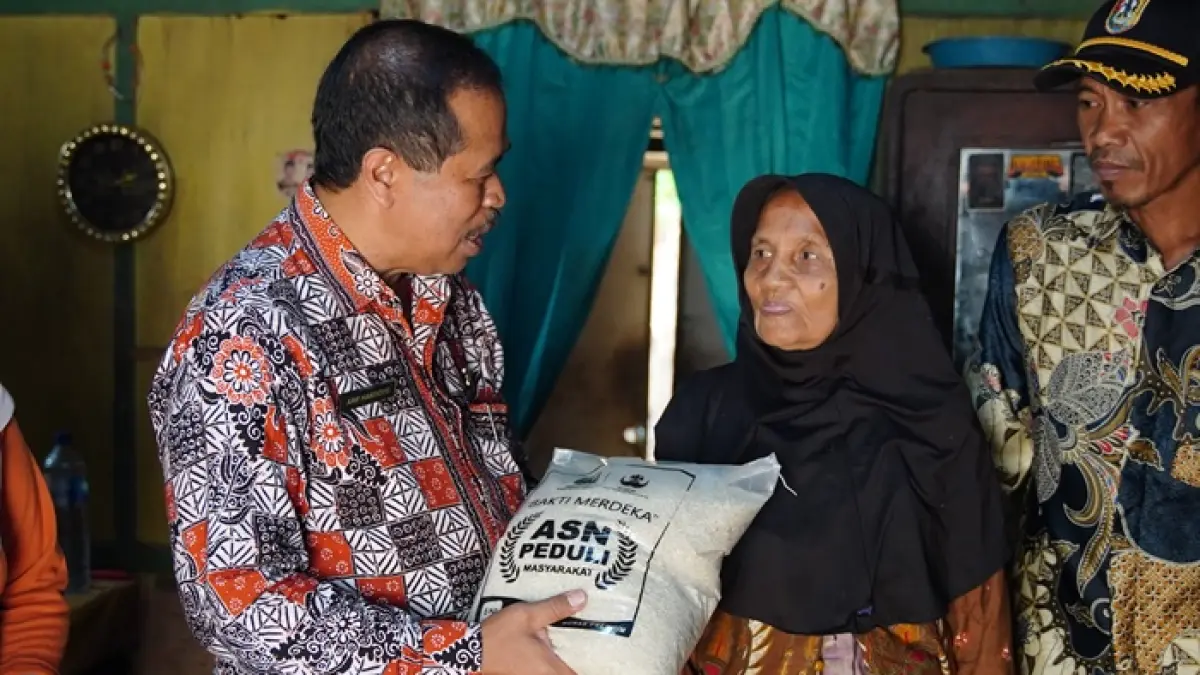Kepala Diskominfo-SP Tuban Arif Handoyo menyerahkan langsung bantuan beras dari ASN Pemkab Tuban kepada warga yang membutuhkan. (Radar Tuban)