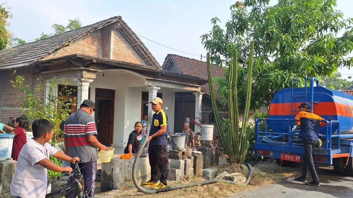 Warga Desa Sugihwaras, Kecamatan Parengan mengantre pasokan air bersih yang disalurWkan oleh petugas BPBD Tuban, Senin (4/8). (BPBD Tuban untuk Radar Tuban)