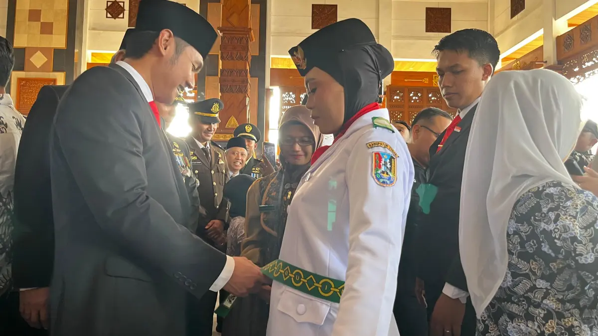 Prosesi pemasangan kendit oleh Bupati Tuban kepada Isna Lutfiya Asrofina saat momen Pengukuhan Paskibraka Kabupaten Tuban. (SHAFA DINA HAYUNING MENTARI/ RADAR TUBAN)