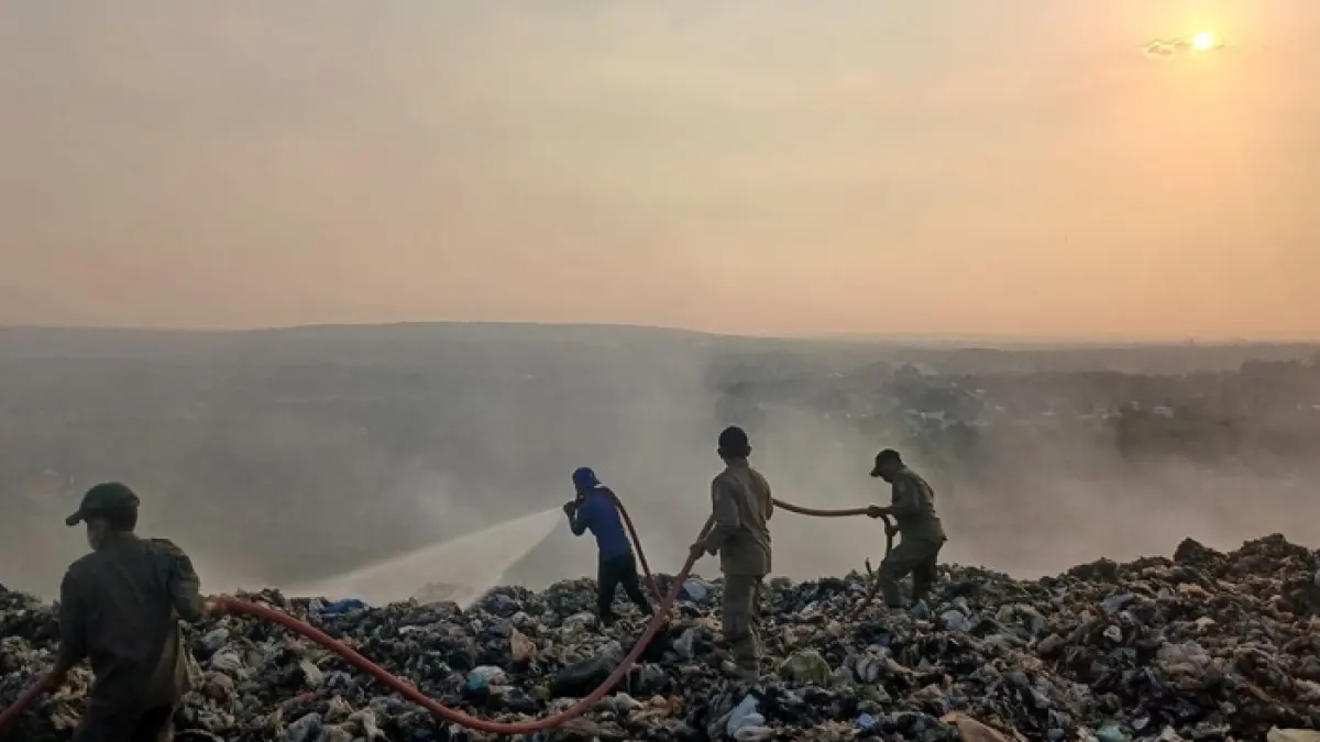 Petugas Damkar Tuban melakukan pemadaman kebakaran di area pembuangan sampah di kompleks TPA Gunung Panggung, Kelurahan Gedongombo, Kecamatan Semanding. (Radar Tuban)