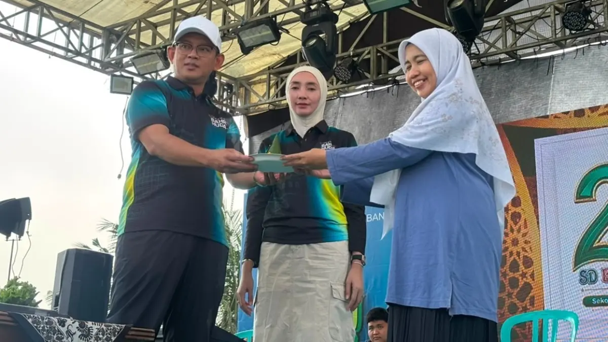 Ketua Umum Yayasan Bahrul Huda Tuban, Gus H.M. Syafiq Syauqi, Lc., M.Ag., bersama istri memberikan potongan tumpeng kepada kepala sekolah. (Radar Tuban)