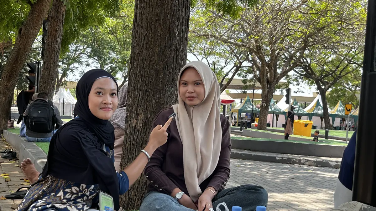 Salah seorang peserta magang Jawa Pos Radar Tuban tengah melakukan wawancara bersama narasumber di Taman Abhipraya Tuban. (Shafa Dina Hayuning Mentari/ Radar Tuban) 