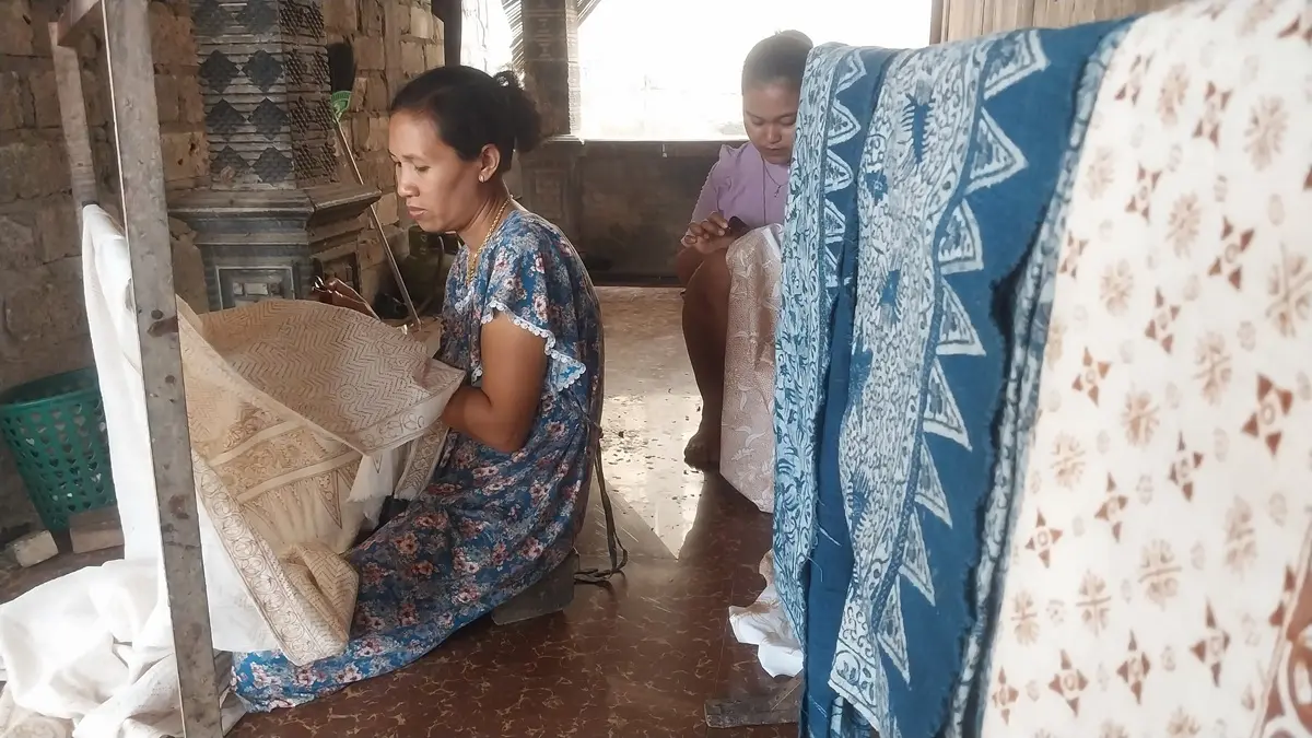 Samiun mengaplikasikan malam panas pada selembar kain putih di rumahnya, Desa Gaji, Kecamatan Kerek. (M.MAHFUDZ MUNTAHA/RADAR TUBAN)