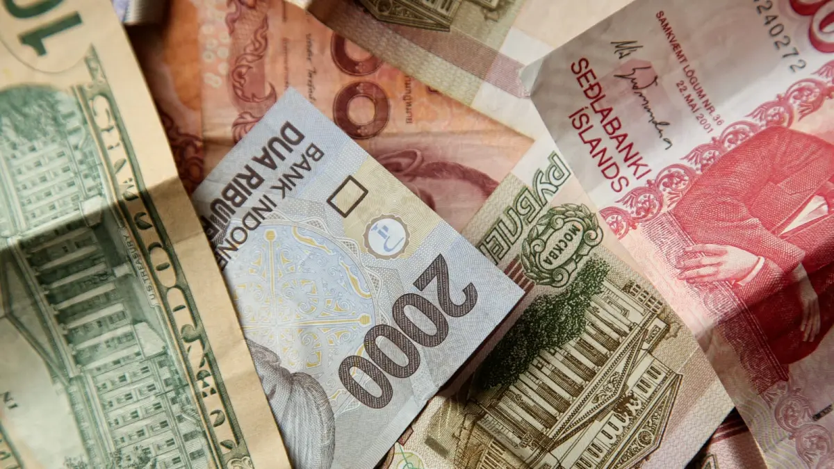 Tumpukan lembaran uang rupiah bersanding dengan kurs asing. (Magnific)