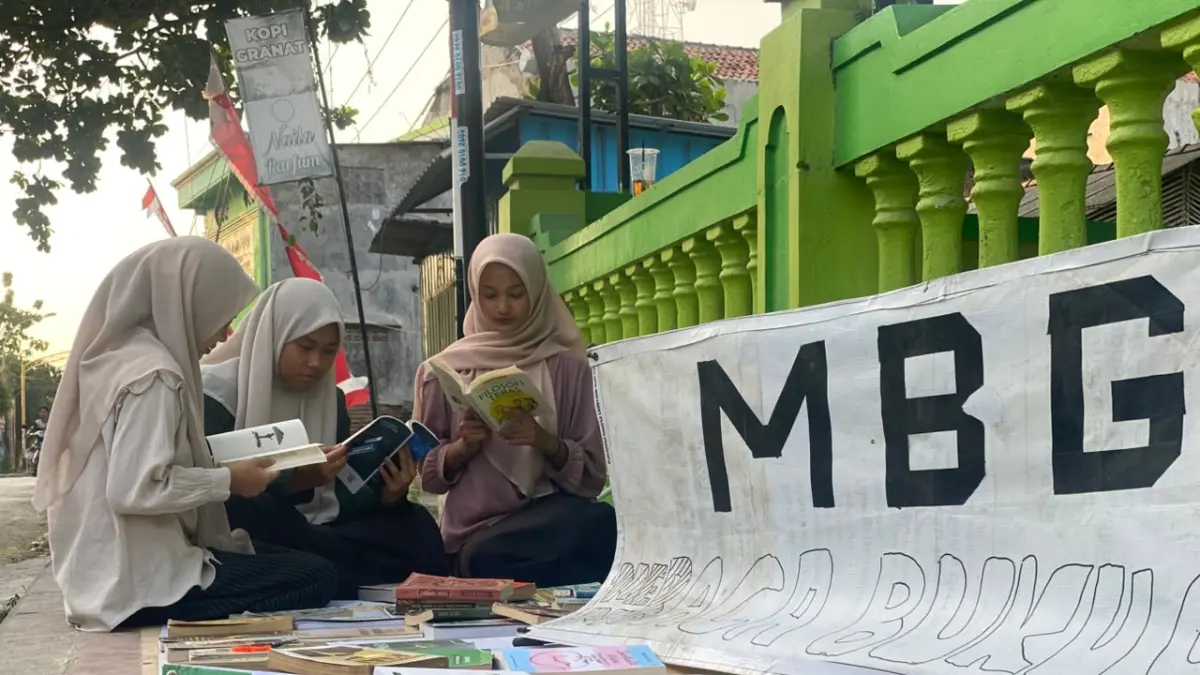 Pengunjung membaca salah satu buku dengan santai di lapak baca milik Omah Baca Santri di Desa Jatisari, Kecamatan Senori. (Radar Tuban)