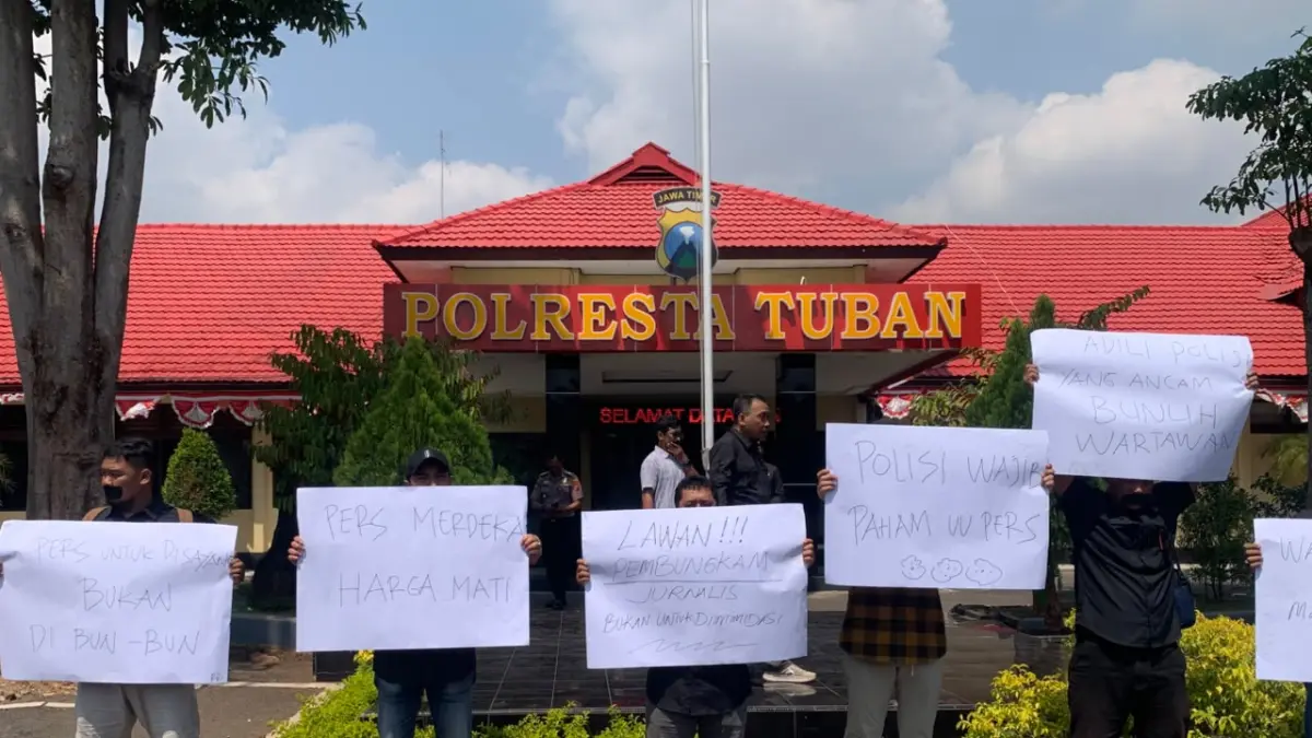 Belasan jurnalis membentangkan spanduk di depan Mapolresta Tuban di Jalan Wahidin Sudiro Husodo dalam aksi demo kemarin (24/8). (M. Mahfudz Muntaha/Radar Tuban)