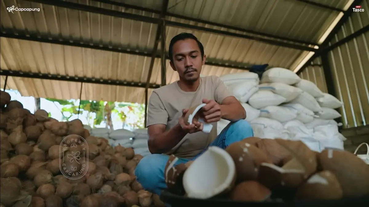 Yosua Putra memilah kelapa tua berkualitas di rumah produksinya, (Tangkapan Layar YouTube CapCapung)