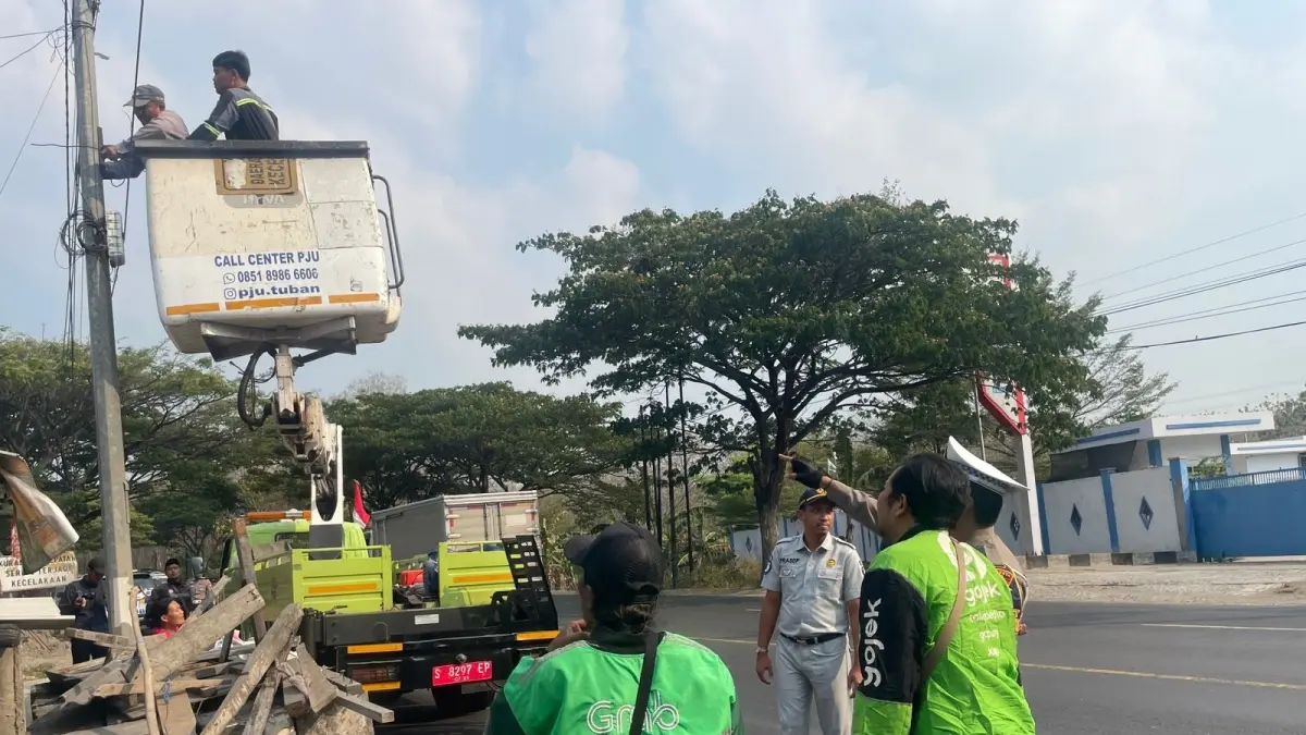 Petugas Satlantas Polres Tuban melakukan pemasangan blue light di titik black spot di Jalan Tuban-Widang, persisnya di Desa Gesing, Kecamatan Semanding. (Radar Tuban)