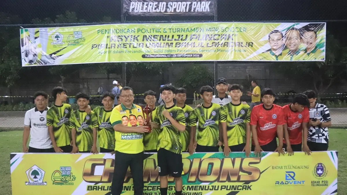 Ketua DPD Partai Golkar Jawa Timur Ali Mufthi menyerahkan piala juara 1 Bahlil Mini Soccer Asyik Menuju Puncak Zona 3 Tulungagung pada tim SMAN 1 Kauman usai partai final yang menegangkan pada Selasa malam (8/9). (DEVRAT RAMANDA/RADAR TULUNGAGUNG)