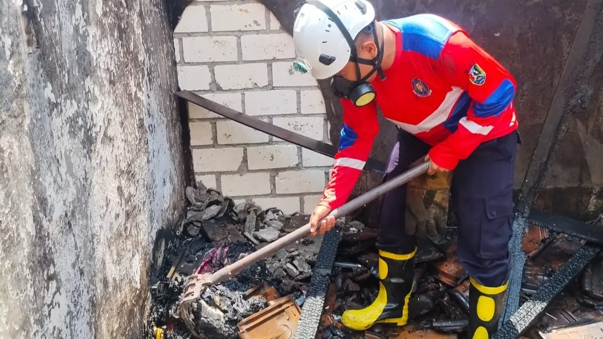 Damkar Tuban tengah melakukan pembasahan di atas puing-puing rumah yang ludes terbakar, Senin (21/9). (Damkar Tuban untuk Radar Tuban)