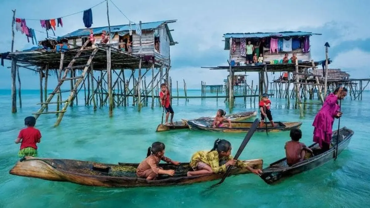 Potret aktivitas harian anak-anak Suku Bajau di atas rumah panggung terapung di kawasan pesisir. (Pinterest)