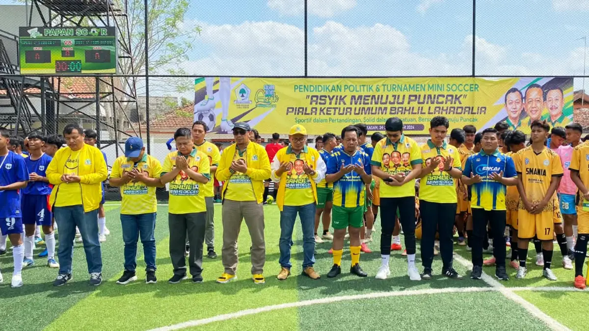 Ketua Panitia Bahlil Mini Soccer Arif Fathoni (topi kuning), Direktur JPRM Abdul Aziz (empat dari kiri) beserta bersama pengurus DPD Partai Golkar Jatim dan pengurus DPD Partai Golkar se-Madura memanjatkan doa bersama para peserta. (FAHMI JALIL/RADAR MADURA)