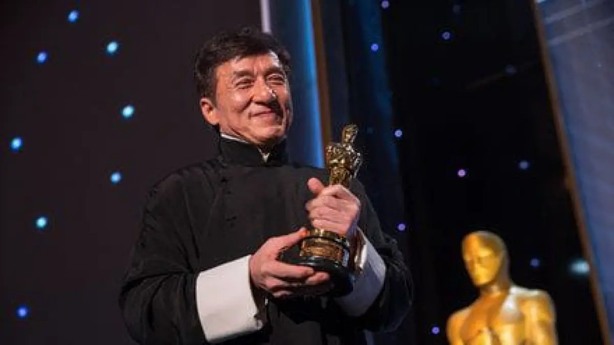 Jackie Chan memegang piala Oscar, momen keemasan kariernya. (pinterest.com)
