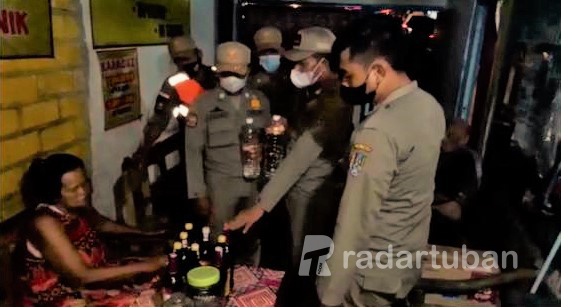 BARANG ILEGAL: Personel Satpol PP Damkar Tuban mengamankan miras dari warung di eks lokalisasi.