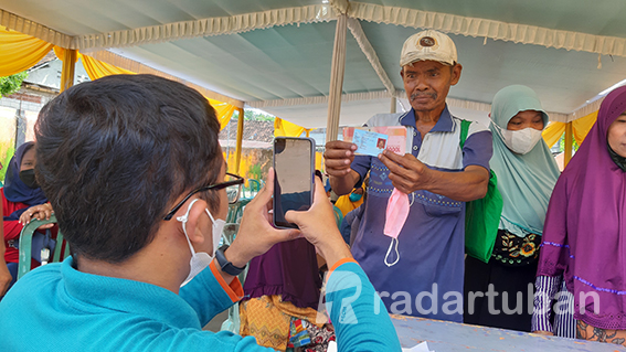 PLONG, BANTUAN CAIR: Penerima manfaat bantuan sosial di Tuban yang kemarin (14/4) antre di tenda Kantor Pos Tuban untuk mencairkan BLT minyak goreng dan BPNT. / M. Mahfudz Muntaha