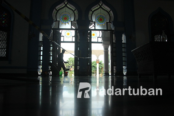 MEMOLES LANTAI: Petugas kebersihan saat memoles keramik Masjid Agung sekaligus membersihkan sisa stiker jaga jarak. / Yudha Satria Aditama