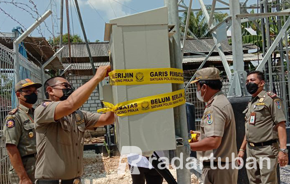 ILEGAL: Petugas Satpol PP Tuban saat melakukan penyegelan tower provider di Desa Plandirejo, Kecamatan Plumpang yang didirikan tanpa izin.