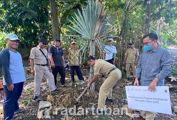 UPAYA KONSERVASI AIR: Kepala Desa Ngimbang Yayik Achmad (mencangkul), Perwakilan EMCL Febry Silaban (kanan, pegang papan) bersama warga menanam 100 pohon palem di desa setempat, Kamis (12/5).
