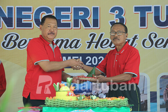 RANGKAIAN ULANG TAHUN: Kepala SMAN 3 Tuban Nuryono memotong tumpeng untuk diserahkan kepada pengawas SMA Anis Fatul. / Yudha Satria Aditama