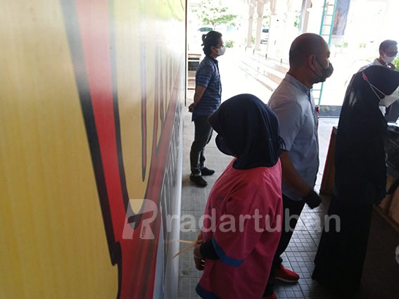 TERTUNDUK MALU: UR menghindari sorotan kamera ketika kasusnnya dirilis Polres Tuban kemarin (11/5). / Yusab Alfa Ziqin