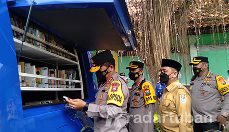 BERI ATENSI LITERASI: Kapolda Jatim Irjen Pol Nico Afinta mengamati koleksi buku mobil Pojok Baca di Rest Area Tuban kemarin (9/5). Dia didampingi Kapolres Tuban AKBP Darman dan Wabup Tuban Riyadi. / Yusab Alfa Ziqin