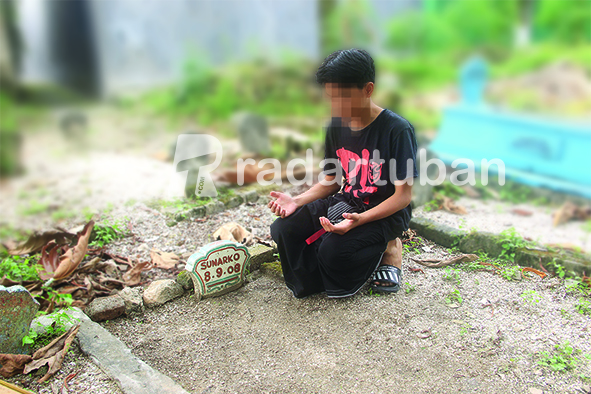MENGADU KE MAKAM AYAH KANDUNG: RWS berada di pusara ayah kandungnya di TPU Kajongan, Kelurahan Sidomulyo, Kecamatan Tuban kemarin (27/5). / Andhika Feriawan