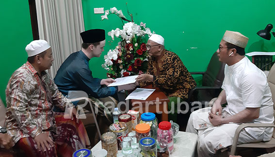 PIMPIN SYAHADAT: Ketua MUI Tuban KH Abdul Matin memimpin Roy Marinus Theodorus membaca Syahadat di kediamannya, Ponpes Sunan Bejagung, Kecamatan Semanding, Sabtu (14/5) malam. / M. Mahfudz Muntaha