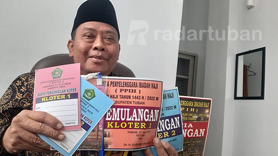 “TIKET” PENJEMPUTAN: Kasi Penyelenggaraan Haji dan Umrah Kemenag Tuban Ashabul Yamin menunjukkan stiker kendaraan penjemput jemaah haji Minggu (17/7) nanti. / M. Mahfudz Muntaha