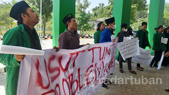 KECEWA: Para pengunjuk rasa menyegel kantor rektorat IAINU Tuban dengan menempel kertas plano bertuliskan “kantor rektorat disegel” dalam aksi kemarin (29/8). / M. Mahfudz Muntaha