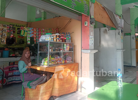 SEGERA ANGKAT KAKI: Kristin ketika menjaga lapaknya di kawasan Rest Area Tuban kemarin (22/8). / Yusab Alfa Ziqin