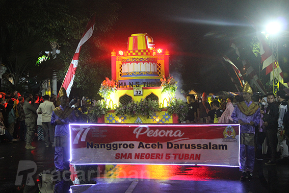 JADI PENGAWAL: Dua siswa berjalan paling depan. Membentangkan banner identitas SMAN 5 Tuban dalam acara TSN Carnival pada Sabtu (27/8) malam. / Andhika Feriawan