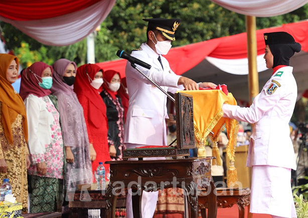 MOMEN SAKRAL: Detik-detik penyerahan bendera Merah Putih oleh Bupati Aditya Halindra Faridzky pada upacara pengibaran bendera di Alun-Alun Tuban kemarin (17/8).