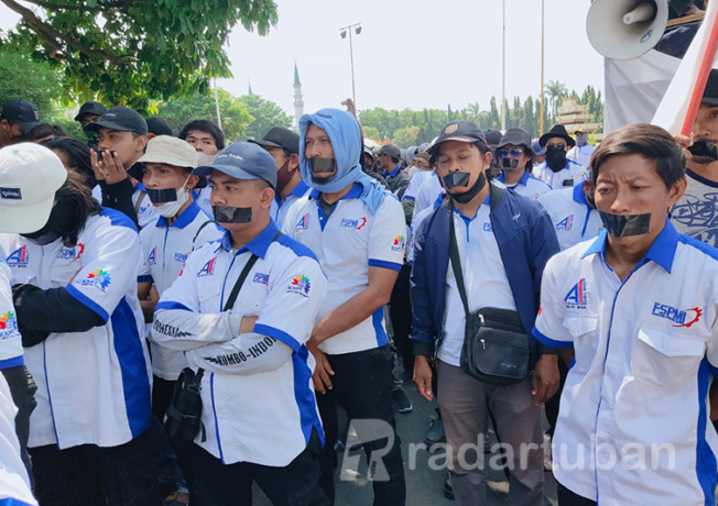 TUTUP MULUT: Massa KC FSPMI Tuban berdemonstrasi di depan gedung Pemkab Tuban Rabu (14/9).