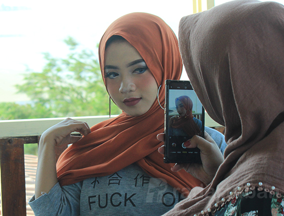 BIKIN KONTEN: Salah satu beauty vlogger saat membuat video tentang kecantikan di salah satu kafe di Kecamatan Jenu. / Yudha Satria Aditama