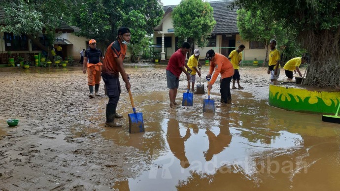SIAP MEMULAI BELAJAR-MENGAJAR: Guru SDN Sumurgung 1 bersama petugas BPBD Tuban membersihkan lumpur di halaman sekolah dan ruang kelas. / M. Mahfudz Muntaha