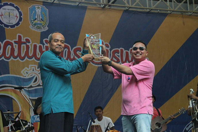 BERI APRESIASI: Kepala SMKN 1 Tuban Subandi, M.Pd memberi penghargaan kepada Guyon Waton, bintang tamu yang memeriahkan acara ulang tahun sekolah. / Yudha Satria Aditama