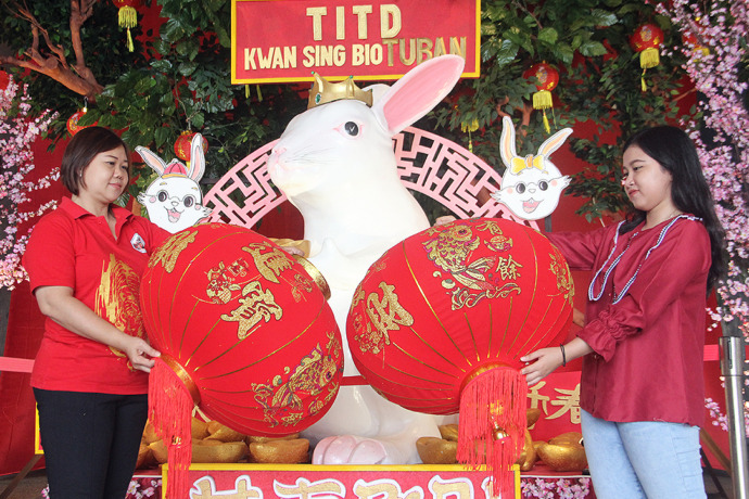 MENYAMBUT IMLEK: Dua karyawati Tempat Ibadah Tri Darma Kwan Sing Bio Tuban memasang lampion dan pernak-pernik menyambut tahun baru China di kelentengnya kemarin (17/1). (Foto: Andhika Feriawan/ Radar Tuban)