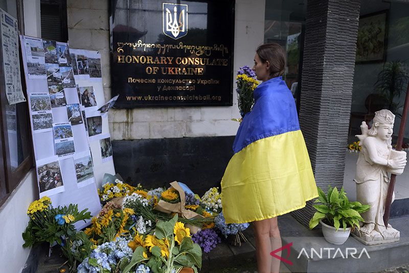 Warga Negara Asing (WNA) asal Ukraina berdoa saat peringatan satu tahun invasi Rusia ke Ukraina di Kantor Konsulat Ukraina, Denpasar, Bali, Jumat (24/2/2023). Kegiatan peletakan bunga disertai doa tersebut untuk memperingati satu tahun invasi Rusia ke Ukr