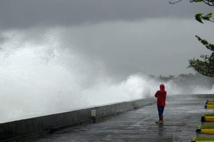 Ilustrasi - Seorang pria mengamati gelombang tinggi di pantai Manado, Sulawesi Utara, Selasa (14/2/2023). ANTARA FOTO/Adwit B Pramono/foc