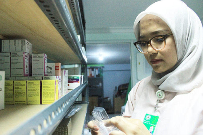 LAYANAN JAM NORMAL: Karyawati salah satu apotek di Tuban memilih obat untuk konsumennya. (Yudha Satria Aditama/Radar Tuban)
