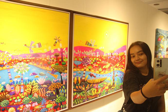 MENARIK PENGUNJUNG: Salah satu pengunjung saat selfie pada pameran seni rupa Titik Kumpul yang digelar di Gedung Budaya Loka Tuban pada Sabtu (18/2) malam. (Yudha Satria Aditama/Radar Tuban)