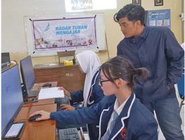 PASTIKAN BISA: Wartawan Jawa Pos Radar Tuban Yusab Alfa Ziqin ketika membimbing salah satu siswi SMK Abdi Negara Tuban yang belajar menulis berita kemarin (28/2). (Andhika Feriawan/Radar Tuban)