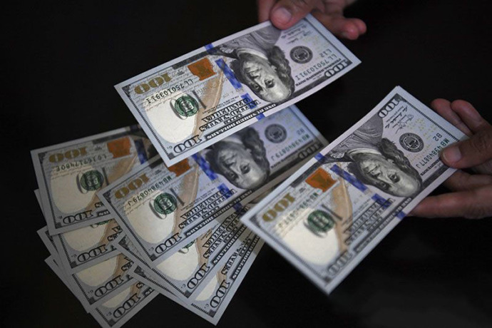Arsip - Petugas melayani penukaran uang dolar Amerika Serikat (AS) di salah satu gerai penukaran valuta asing, Jakarta, Jumat (1/3/2019). ANTARA FOTO/Puspa Perwitasari/ama/pri.