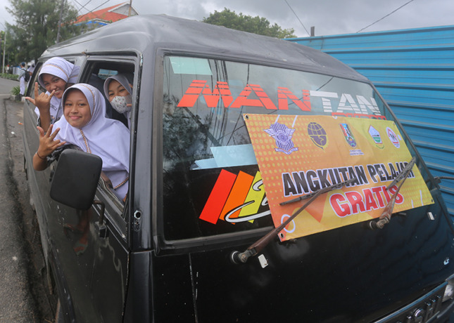 GEMBIRA: Sejumlah siswi MTSN 1 Tuban ketika menumpang Angkutan Pelajar Gratis di Jalan RE Martadinata beberapa waktu lalu. (Yusab Alfa Ziqin/Radar Tuban)