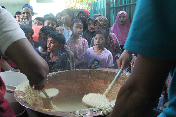 MENJAGA TRADISI: Para pengantre berebut bubur sura di halaman Masjid Muhdor Tuban, Jalan Pemuda kemarin (24/3). (Andhika Feriawan/Radar Tuban)
