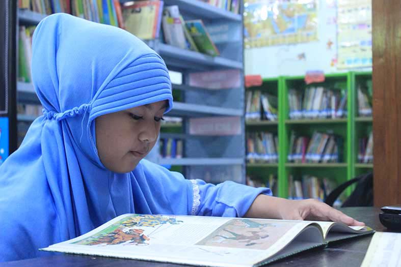 CONTOH BAIK: Siswa SD Bina Anak Sholeh Tuban yang mengisi waktu luangnya untuk membaca buku di perpustakaan sekolah. (Yudha Satria Aditama/Radar Tuban)